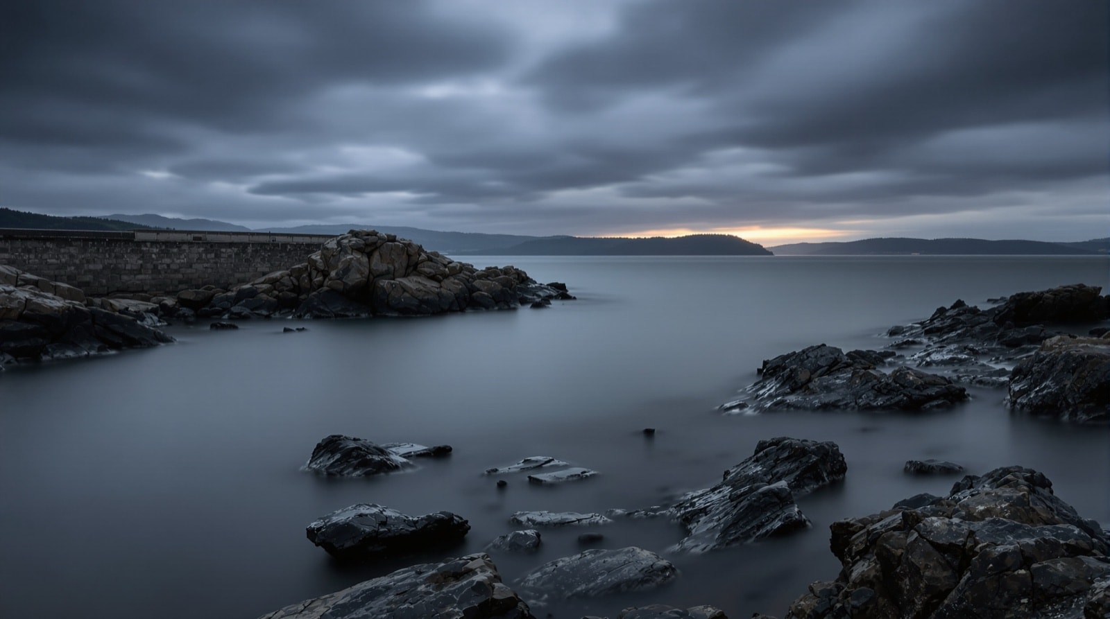 Ría gallega al atardecer con roca de granito y niebla baja